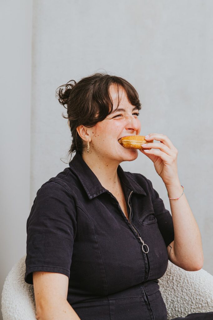 Nora biting into a cinnamon sugar donut.