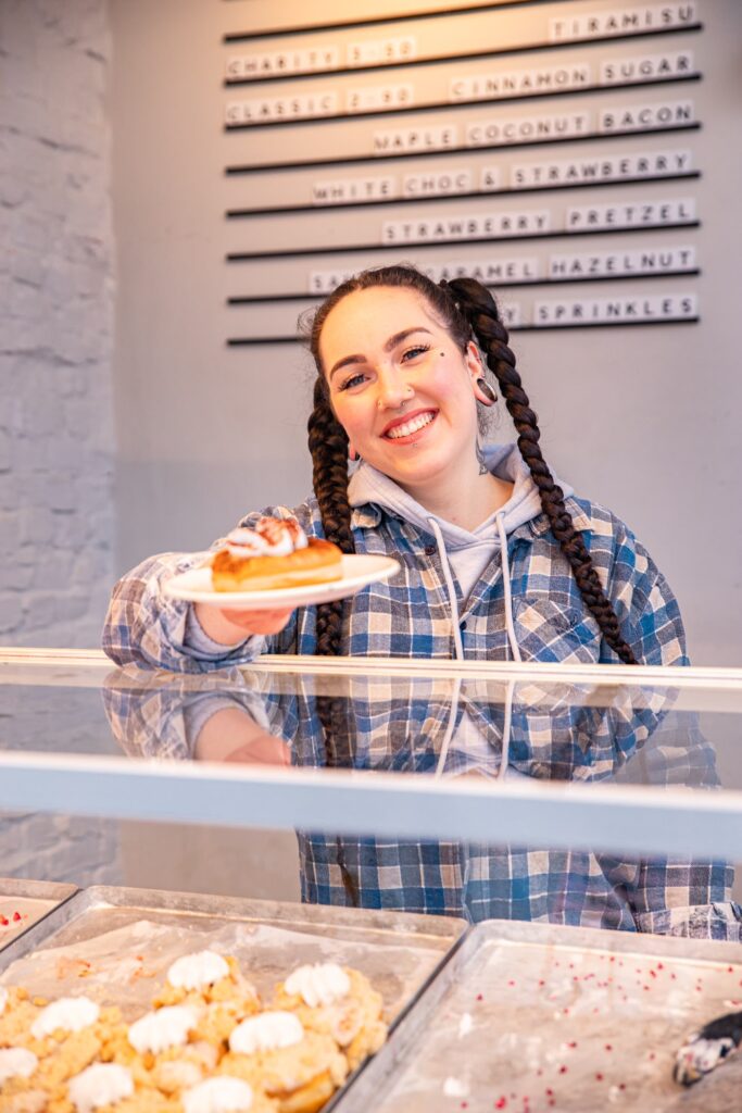 Jana serving a tiramisu donut over the counter. 
