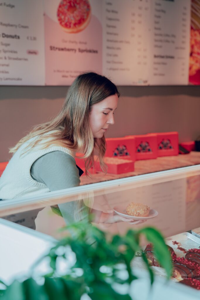 Melissa putting donuts on a plate.